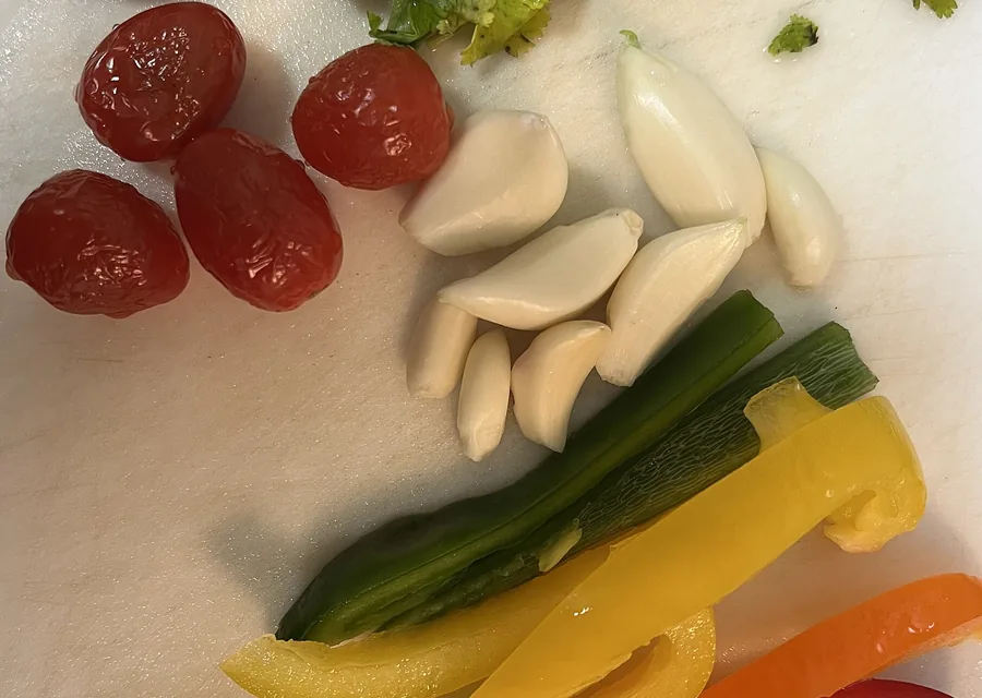 Ajo, jitomate y tiras de pimiento en una tabla